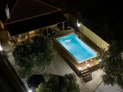 an overhead view of a swimming pool at night at Σπίτι με πισίνα δίπλα στο αεροδρόμιο. in Spáta
