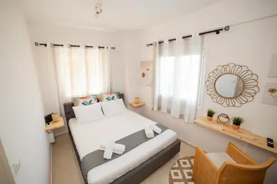 a bedroom with a bed with a mirror and a chair at Σπίτι με πισίνα δίπλα στο αεροδρόμιο. in Spáta