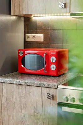 a red microwave sitting on a counter in a kitchen at Σπίτι με πισίνα δίπλα στο αεροδρόμιο. in Spáta