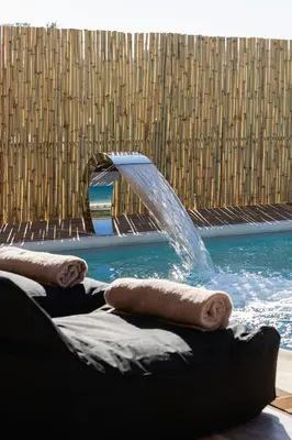 a pool with a water fountain in a building at Σπίτι με πισίνα δίπλα στο αεροδρόμιο. in Spáta