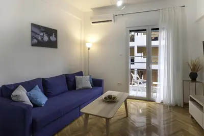 a living room with a blue couch and a table at Phaedrus Living: City Center Koukaki Flat in Athens