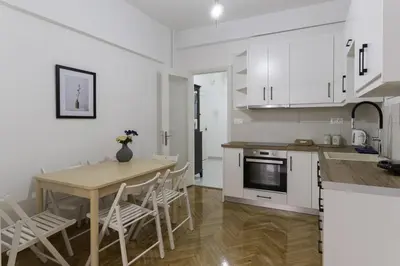 a kitchen and dining room with a table and chairs at Phaedrus Living: City Center Koukaki Flat in Athens