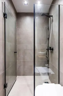 a bathroom with a glass shower and a sink at HeyDay Living South 8 in Athens
