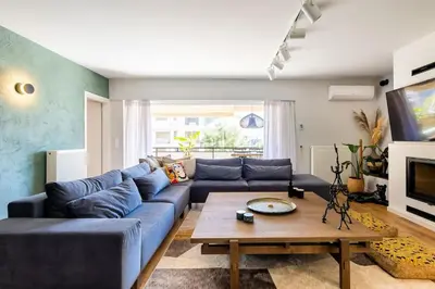 a living room with a blue couch and a table at HeyDay Living South 8 in Athens