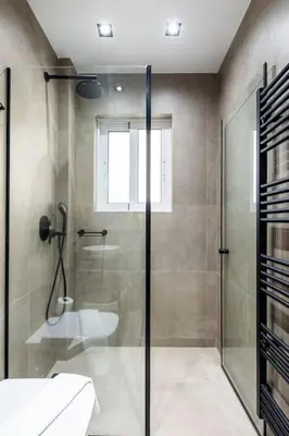 a bathroom with a glass shower and a sink at HeyDay Living South 8 in Athens