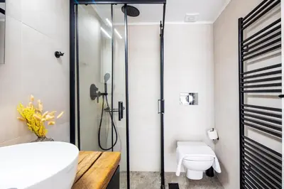 a bathroom with a shower and a toilet and a sink at HeyDay Living South 8 in Athens