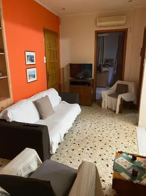 a living room with a couch and a tv at House close to the port Piraeus and metro station in Piraeus