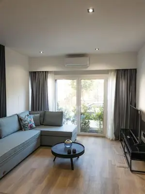 a living room with a couch and a table at Azalea Suite - 5 min drive to Piraeus Port in Piraeus