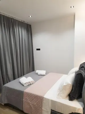a bedroom with a bed with two towels on it at Azalea Suite - 5 min drive to Piraeus Port in Piraeus