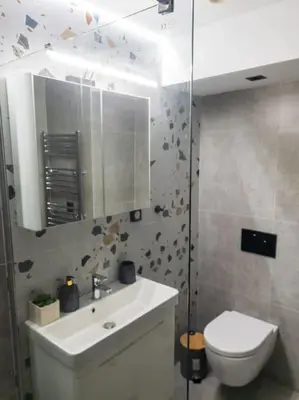 a bathroom with a sink and a toilet and a mirror at Azalea Suite - 5 min drive to Piraeus Port in Piraeus