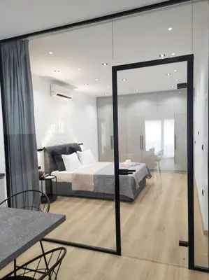 a bedroom with a bed and a large glass window at Dahlia Suite - 5 min drive to Piraeus Port in Piraeus