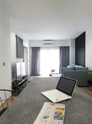 a laptop sitting on a counter in a living room at Dahlia Suite - 5 min drive to Piraeus Port in Piraeus
