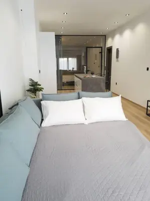 a large bed with white pillows in a room at Dahlia Suite - 5 min drive to Piraeus Port in Piraeus