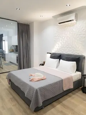 a bedroom with a bed with a robe on it at Dahlia Suite - 5 min drive to Piraeus Port in Piraeus