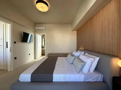 a bedroom with a large bed with white pillows at BlueMotion - SkytouchSuite in Piraeus