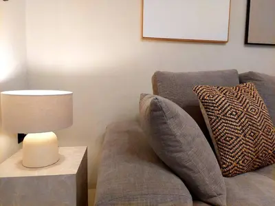 a living room with a couch and a table with a lamp at BlueMotion - SkytouchSuite in Piraeus