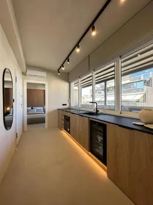 a large kitchen with a counter top and windows at BlueMotion - SkytouchSuite in Piraeus