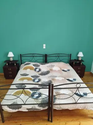 a bed in a bedroom with a blue wall at Pilika4 in Athens