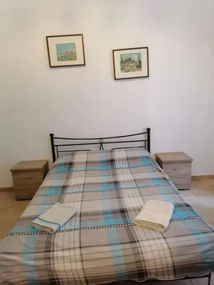 a bed with a plaid blanket on top of it at Pilika4 in Athens