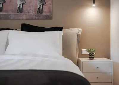 a bedroom with a white bed and a night stand at Vouliagmeni Stylish Apartment in Athens