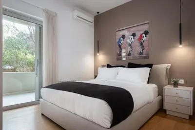 a bedroom with a large bed and a large window at Vouliagmeni Stylish Apartment in Athens