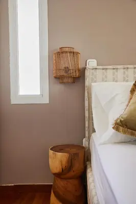 a bed with a wooden stool sitting next to a bed at Athens Riviera Villa in Anavissos