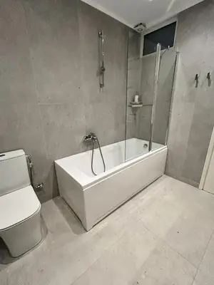 a bathroom with a white tub and a toilet at Athens Riviera Villa in Anavissos