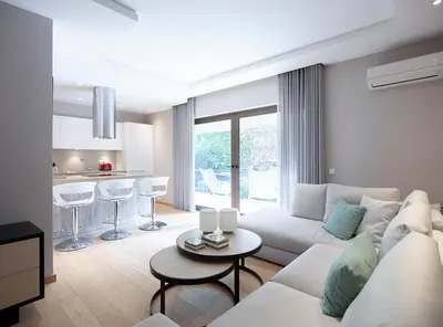 a living room with a white couch and a kitchen at Athenian Riviera Exclusive flat , Athens Greece in Athens