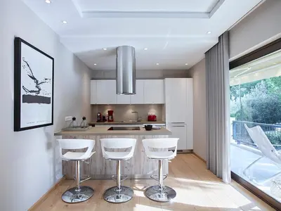a kitchen with white bar stools and a large window at Athenian Riviera Exclusive flat , Athens Greece in Athens