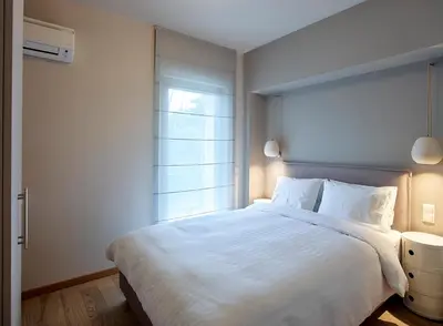 a bedroom with a large white bed and a window at Athenian Riviera Exclusive flat , Athens Greece in Athens