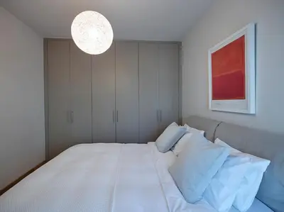 a bedroom with a large white bed with a light at Athenian Riviera Exclusive flat , Athens Greece in Athens