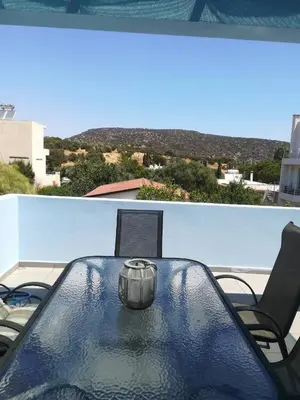 a table and chairs on a balcony with a view at Mina’s Villa, 200m from the beach in Porto Rafti