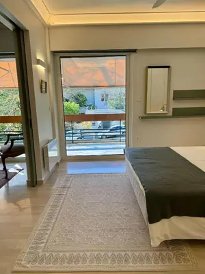 a bedroom with a bed and a large window at Peter's Place in Athens