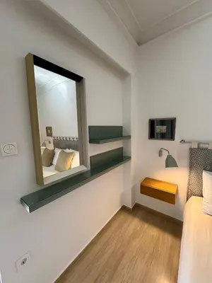 a small bedroom with a mirror and a bed at Peter's Place in Athens