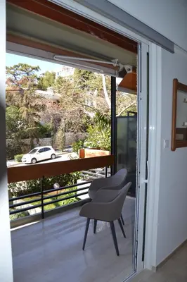 a room with a chair and a window with a view at Peter's Place in Athens