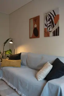 a white couch in a living room with pillows on it at Cozy 1Bdrm Apt/walk to the beach in Athens