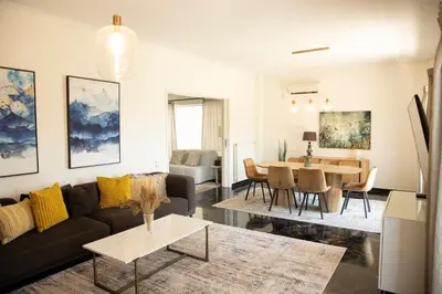 a living room with a couch and a table at Spacious Glyfada Golf 4BR -Near Beach + Shops in Athens