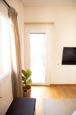 a room with a window and a plant in front of a door at Spacious Glyfada Golf 4BR -Near Beach + Shops in Athens