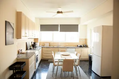 a kitchen with a table and chairs and a ceiling fan at Spacious Glyfada Golf 4BR -Near Beach + Shops in Athens
