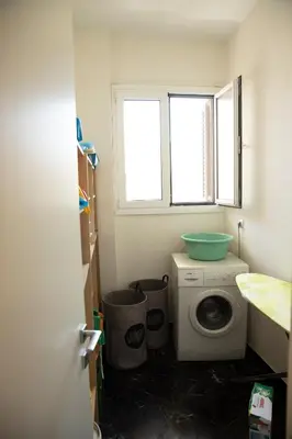 a small bathroom with a washing machine and a window at Spacious Glyfada Golf 4BR -Near Beach + Shops in Athens