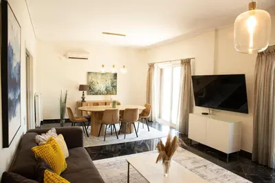 a living room with a couch and a table at Spacious Glyfada Golf 4BR -Near Beach + Shops in Athens