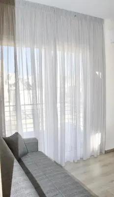 a living room with a couch and a large window at Piraeus Relax in Piraeus