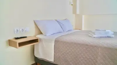 a bed with two towels and a night stand next to it at Piraeus Relax in Piraeus