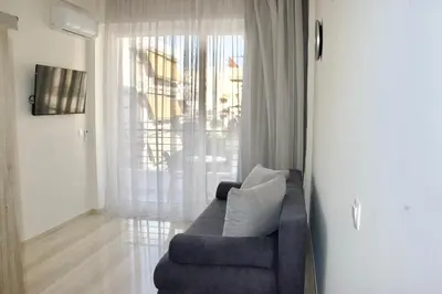 a living room with a couch and a large window at Piraeus Relax in Piraeus