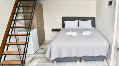 a bedroom with a bed with a ladder next to it at Piraeus Relax in Piraeus