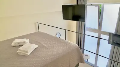 a bedroom with two towels on a bed with a television at Piraeus Relax in Piraeus