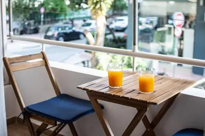 a wooden table with two glasses of orange juice on it at ARIS Ampelokipoi in Athens