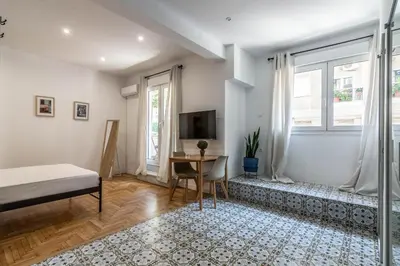 a bedroom with a bed and a table and a tv at ARIS Ampelokipoi in Athens