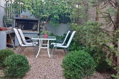 a table and four chairs in a garden at Pela's studio 10 minutes from the Athens airport in Leondárion
