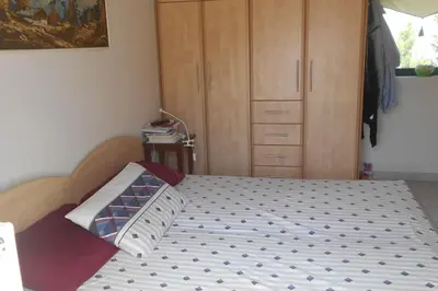 a bedroom with a bed and a wooden cabinet at Pela's studio 10 minutes from the Athens airport in Leondárion